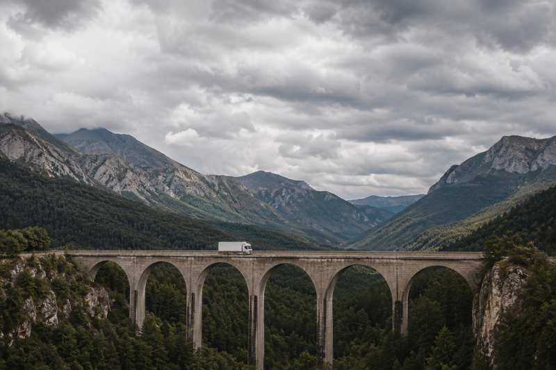 Camion de déménagement franchissant un viaduc de montagne